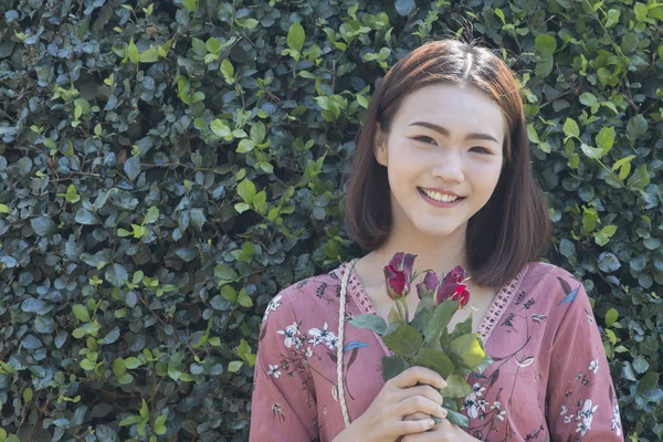 Gelukkig Aziatische vrouwen houden van rode rozen — Stockfoto