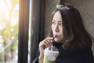  kadın Dinkleyen buzlu yeşil çay 