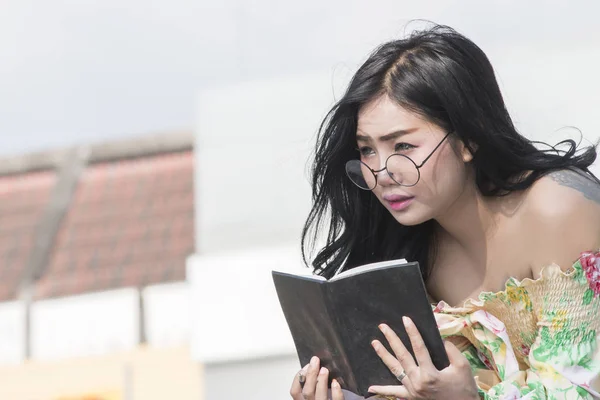 Asiatico donna con occhiali sta scrivendo nel libro — Foto Stock