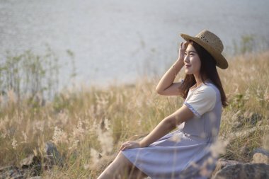 Genç Asyalı kadınlar saman ile rahatlatıcı ourdoor, yaşam tarzı kavramı şapka