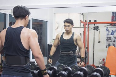 Spor salonunda ayna önünde Asya sporcu stand