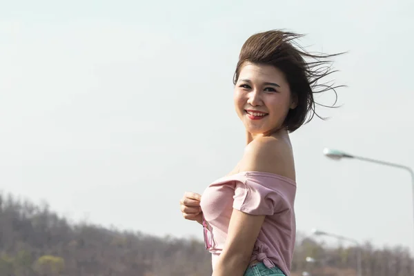 Portrait of a cute asian young woman stand against blue sky and — 스톡 사진