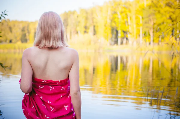 Nude girl in sedge. young blonde woman with bare breasts, wrapped in a red cloth, standing in the reeds — Stock Photo, Image