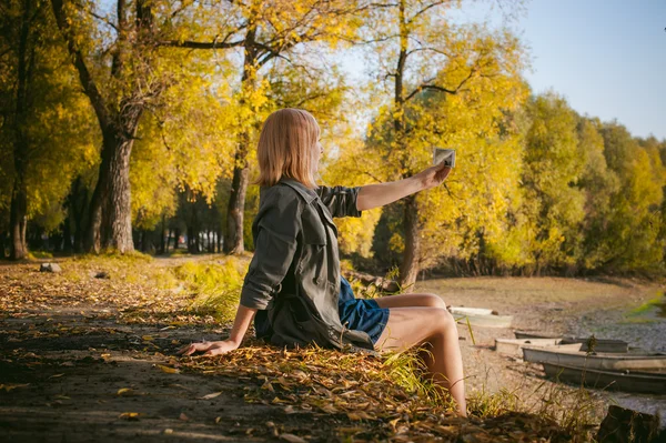 Pretty blonde girl in sneakers photographed on a smartphone selfie — Stock Photo, Image