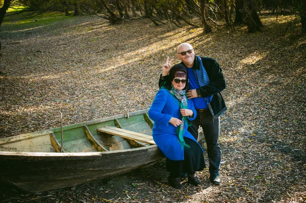 adult couple walking in autumn park. husband and wife walking outdoors in autumn last days