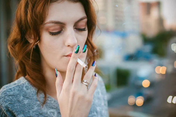 Meisje met een sigaret. mooie jonge vrouw rookt een sigaret in de straat — Stockfoto