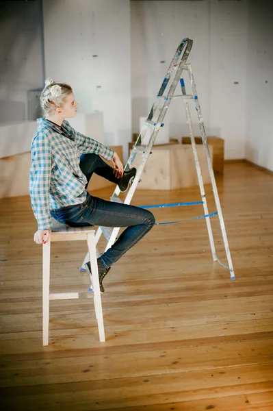 Niña y escalera de construcción. estudio de una mujer joven con una escalera de construcción en la habitación — Foto de Stock