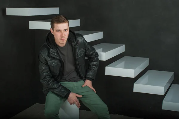 Fotografía de estudio de un joven con una camiseta oscura, chaqueta de cuero negro . —  Fotos de Stock