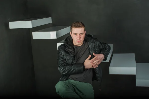 Fotografía de estudio de un joven con una camiseta oscura, chaqueta de cuero negro . —  Fotos de Stock