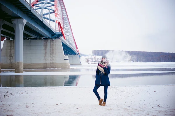 Vaping flicka. vinter gatan porträtt av en kvinna hipster, lila-färgade hår, en grå Stickad mössa och halsduk. kvinnan röker en elektronisk cigarett i gata nära floden snötäckta — Stockfoto