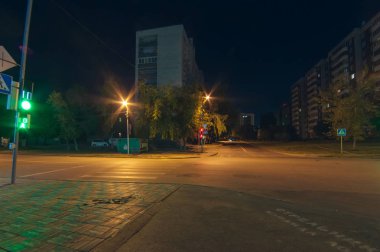ıssız gece kavşak trafik ışıkları ve yaya geçitleri ile. ışıklar, ağaçlar ve evler, Novosibirsk şehir sokak fonunda