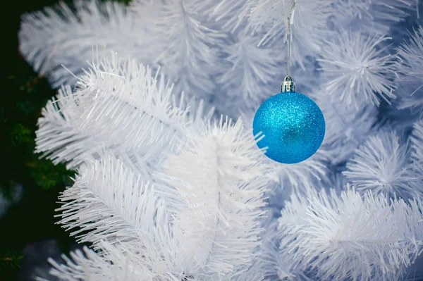 Blauwe bal op een close-up shot van witte kerstboom — Stockfoto