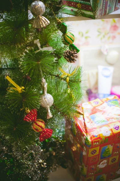 Egy kis karácsonyfa, dekorációs játék, karamell cukorkák, az új évet ajándékok formájában — Stock Fotó
