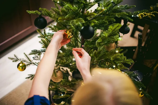 Weibliche Hände schmücken einen Weihnachtsbaum — Stockfoto