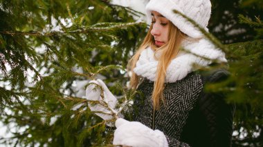 Kar açık havada arka plan üzerinde beyaz atkı ve şapka örme ceket sevimli kadın portresi 