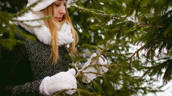 Porträtt av söt kvinna i vit halsduk och mössa stickad kappa på utomhus bakgrund av snö — Stockfoto