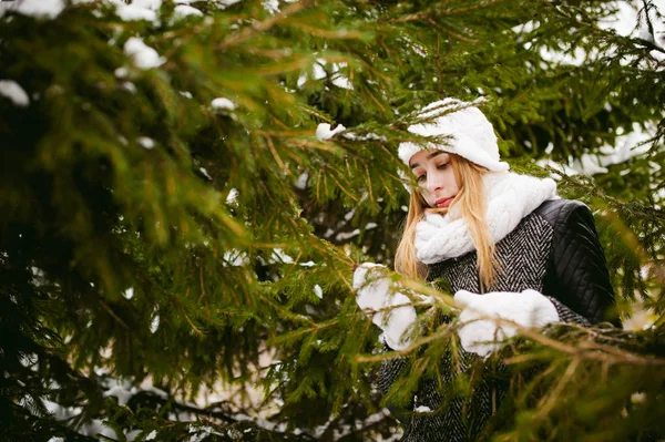Портрет милой женщины в белом шарфе и шапке трикотажного пальто на открытом фоне снега — стоковое фото