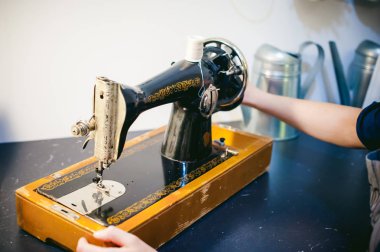 terzi dikiş makinesi çalışmalarına. Genç sarışın kadın evde mekanik bir dikiş makinesinde çalışma masanızın başında oturan dikmek için hazır olun