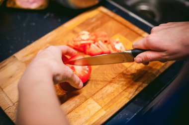 kadın ev kadını mutfakta. kadın sebze, yemek, bir kesme tahtası üzerinde bıçak keser. Eller aşçılar yakın çekim
