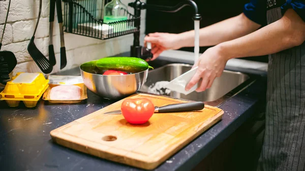Mulher dona de casa na cozinha. mulher corta verduras, cozinha, faca em uma tábua de corte. Mãos cozinheiros perto — Fotografia de Stock