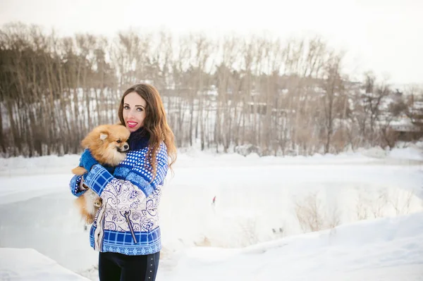 スピッツ犬野外を歩いている女性と遊ぶ冬の日、暖かい服 — ストック写真