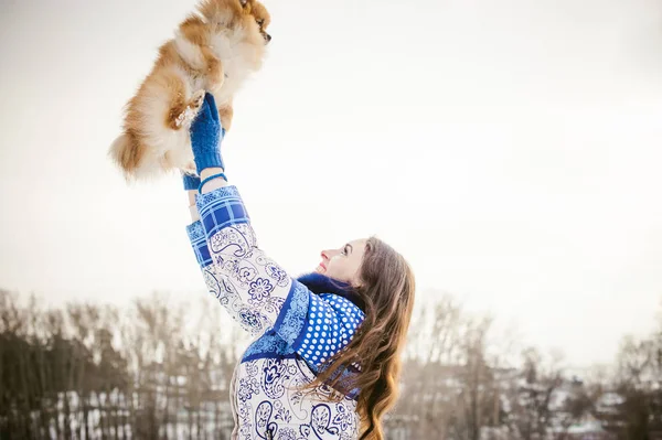 Lächelnde Frau, die ihren Hund in der Nähe des Gesichts in den Händen hält und sich über den Kopf wirft. — Stockfoto