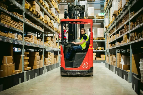 young man in working clothes, driver Reachtruck busy working on the logistics warehouse store