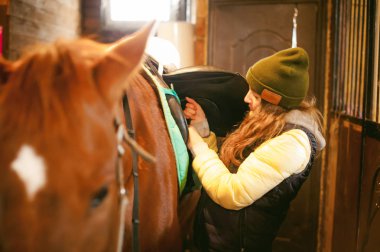 bir at ahır içinde hazırlamak beri kalkış için genç kadın binici nişanlı