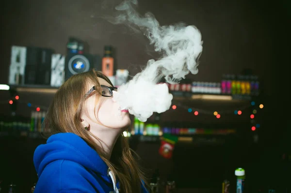 Bela jovem com óculos fumar cigarro eletrônico — Fotografia de Stock