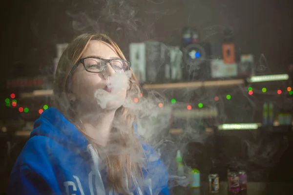 Bela jovem com óculos fumar cigarro eletrônico — Fotografia de Stock