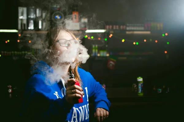 Bela jovem com óculos fumar cigarro eletrônico — Fotografia de Stock