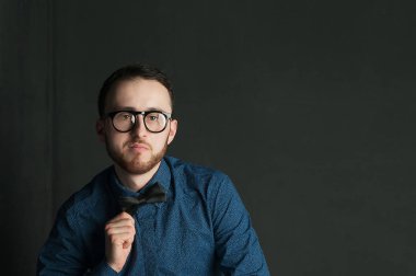 karanlık duvar arka plan mavi tişört ve kot üzerinde genç hippi erkek portresi stüdyo. 