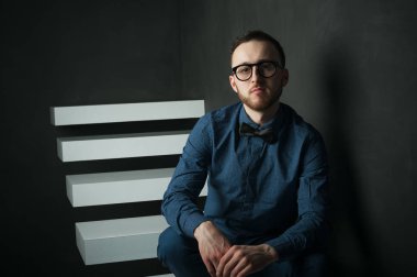 karanlık duvar arka plan mavi tişört ve kot üzerinde genç hippi erkek portresi stüdyo. 