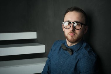 karanlık duvar arka plan mavi tişört ve kot üzerinde genç hippi erkek portresi stüdyo. 