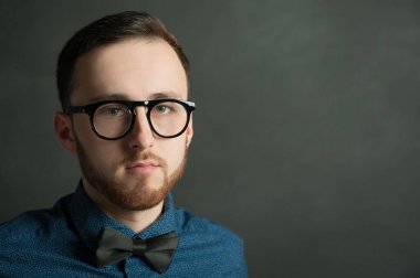 karanlık duvar arka plan mavi tişört ve kot üzerinde genç hippi erkek portresi stüdyo. 