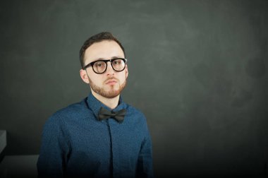 karanlık duvar arka plan mavi tişört ve kot üzerinde genç hippi erkek portresi stüdyo. 