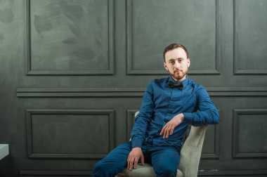 karanlık duvar arka plan mavi tişört ve kot üzerinde genç hippi erkek portresi stüdyo. 