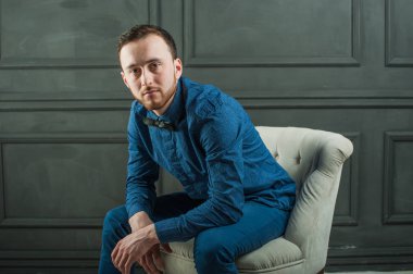 karanlık duvar arka plan mavi tişört ve kot üzerinde genç hippi erkek portresi stüdyo. 