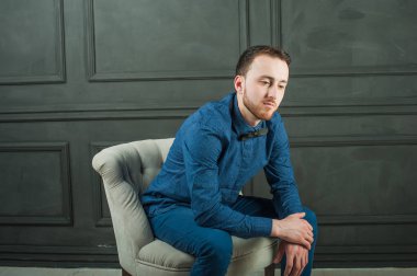 karanlık duvar arka plan mavi tişört ve kot üzerinde genç hippi erkek portresi stüdyo. 