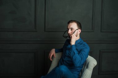 karanlık duvar arka plan mavi tişört ve kot üzerinde genç hippi erkek portresi stüdyo. 