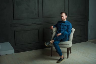 karanlık duvar arka plan mavi tişört ve kot üzerinde genç hippi erkek portresi stüdyo. 