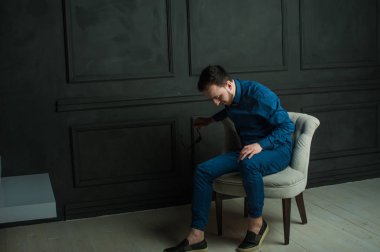 karanlık duvar arka plan mavi tişört ve kot üzerinde genç hippi erkek portresi stüdyo. 