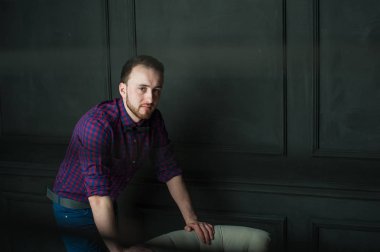 karanlık duvar arka plan mavi tişört ve kot üzerinde genç hippi erkek portresi stüdyo. 