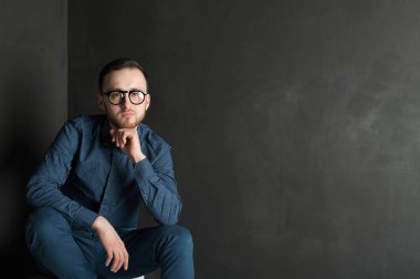 karanlık duvar arka plan mavi tişört ve kot üzerinde genç hippi erkek portresi stüdyo. 