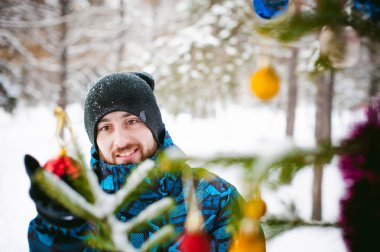 Erkekler bir kış Parkta yürümek. iyi mizah ve gülümseme ile çocuk, giyim açık havada yürüyüş sıcak, sokakta bir Noel ağacı süslemeleri Giydir