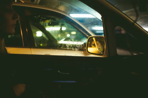 Het meisje in de auto op de parkeerplaats — Stockfoto