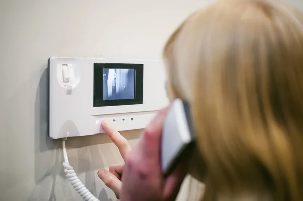 sarışın kadın Telefonu kulağınıza tutarken Interkom çağrıyı yanıtlar