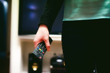 bir Tv uzaktan kumanda, kanallar anahtarlama tutan kız ev ortamında,