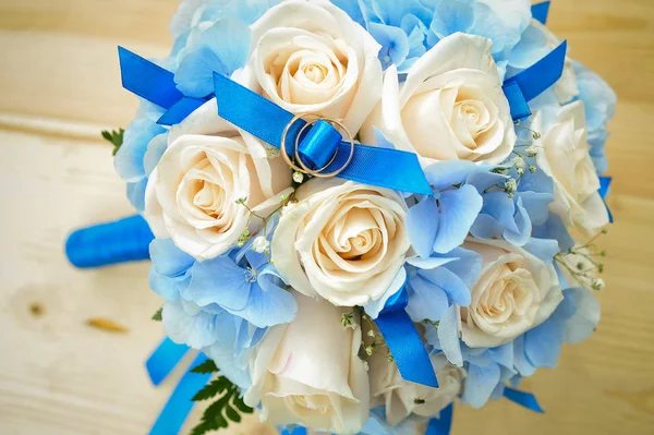 Svatební kytice a novomanželé kroužky. manželství kruhy na bílé růže — Stock fotografie
