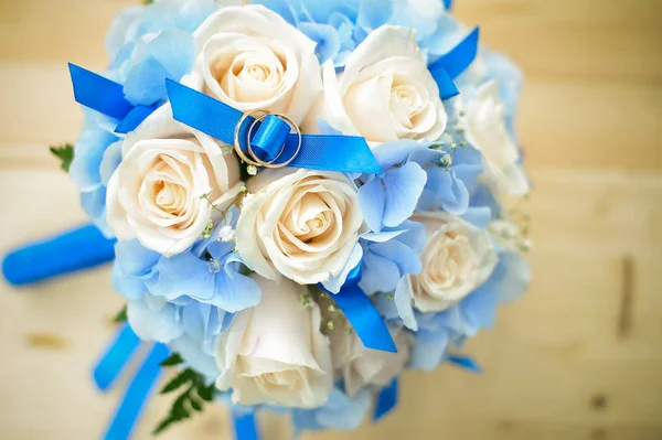 Svatební kytice a novomanželé kroužky. manželství kruhy na bílé růže — Stock fotografie